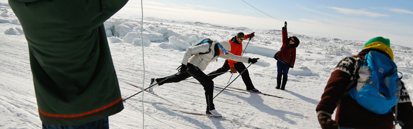 Image of people cross-country skiing and having fun on a sunny day on the sea ice in Nunavut.