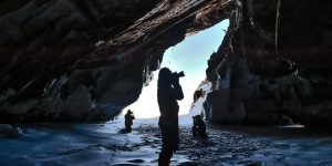 Image of three photographers in an arctic cave near the tundra in Nunavut.