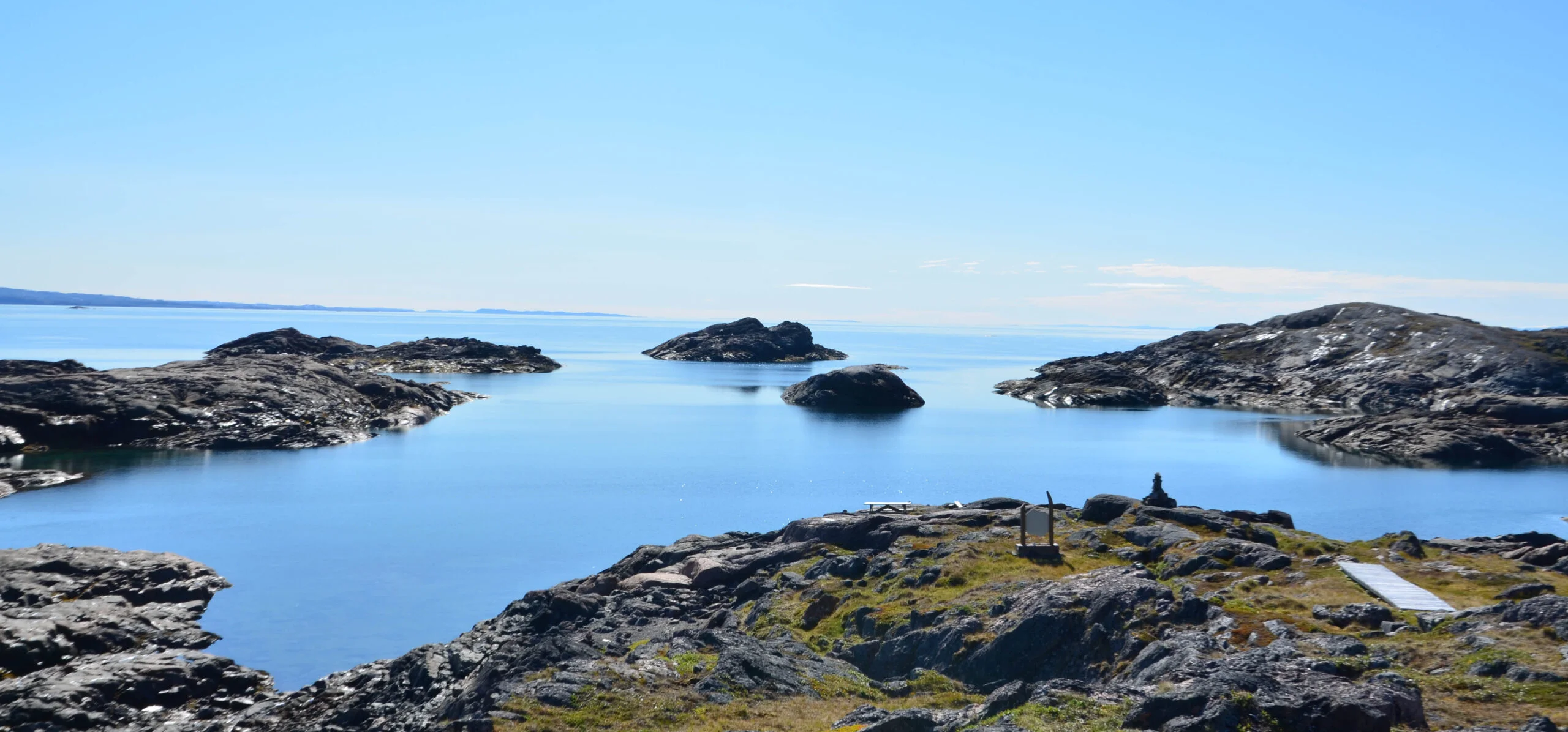 Picturesque view of glass-like water and rocks in Qaummaarviit